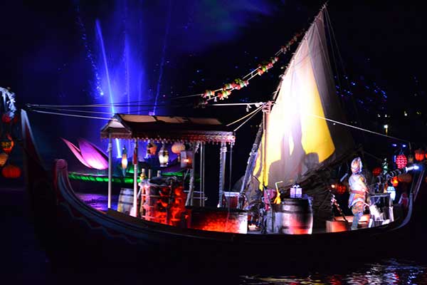 The boat and shaman entertain the crowd for Rivers of Light at Disney's Animal Kingdom.
