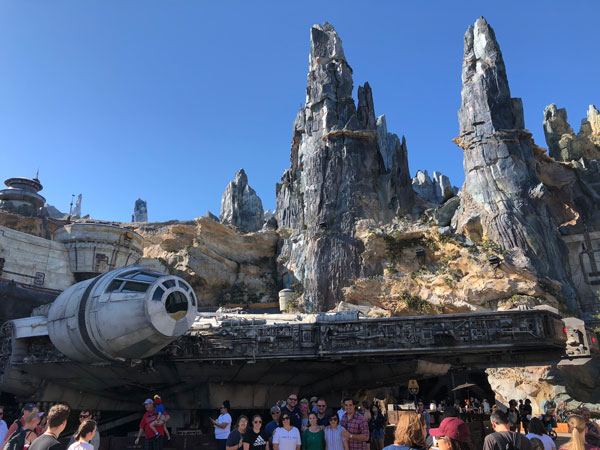An epic shot of Star Wars: Galaxy's Edge with the Millennium Falcon in the foreground.