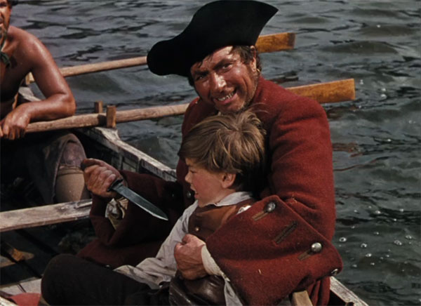 Long John Silver threatens Jim Hawkins as they venture out looking for Captain Flynn's big score.