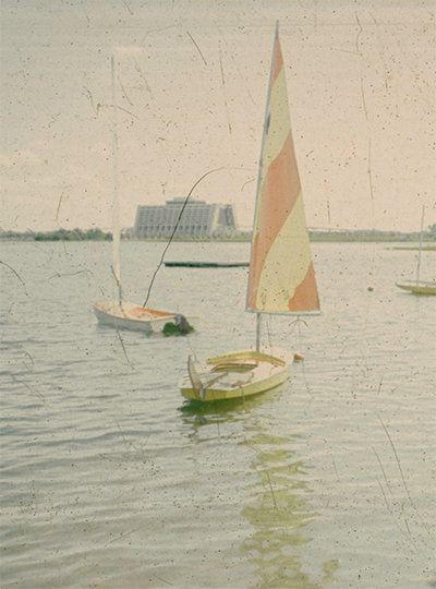 Lonely watercraft are ready for guests in 1975 at the Seven Seas Lagoon with the Contemporary Resort in the background.