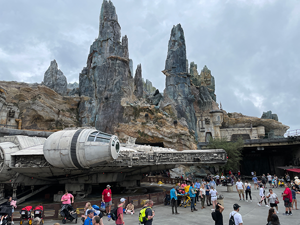 The striking backdrop of the Black Spire Outpost at Star Wars: Galaxy's Edge with the Millennium Falcon in front of it. 